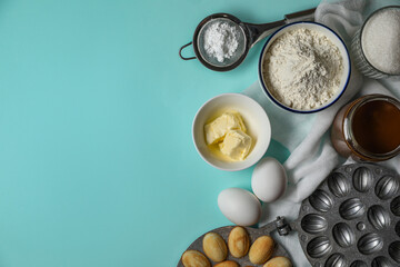 Freshly baked homemade walnut shaped cookies, baking dish and ingredients on light blue table, flat lay. Space for text