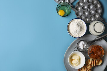 Baking mold and ingredients for walnut shaped cookies on light blue table, flat lay. Space for text