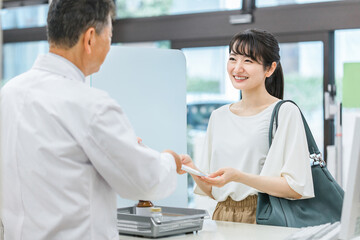 薬局に処方せん受け取り・買い物に来た女性
