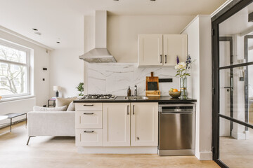 a modern kitchen with marble counter tops and white cabinetry in the room is well lit by the large window