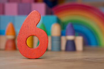 Wooden six on rainbow background