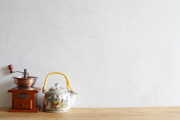Vintage manual coffee grinder and ceramic traditional chinese tea pot, coffee versus tea comparison