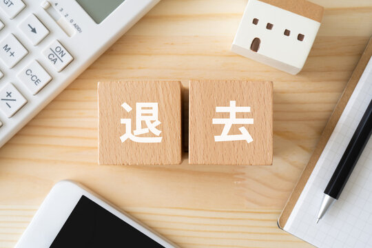 退去と書かれたブロック、電卓、スマホ、ミニチュアの家