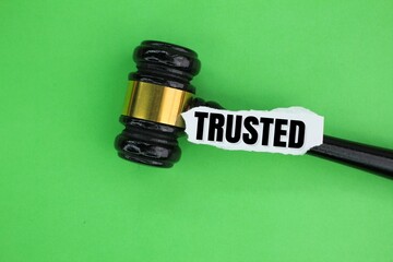 judge's gavel and torn paper with the word Trusted. reliable concept or trusted company