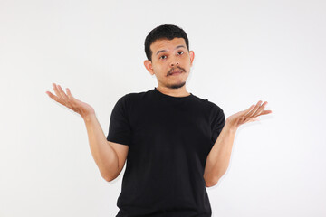 Young adult asian man raised arms and looking at camera with doubtful face. studio shot, isolated on light grey background.