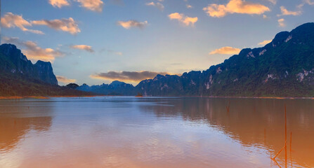 Fototapeta premium The Aerial sunset view at Khao Sok national park Cheow Lan Dam lake with blue sky background in Surat Thani, Thailand