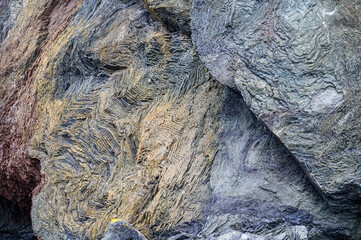 Interesting geologic feature in rock layers with colorful lichen, patterns and texture in nature, as a nature background
