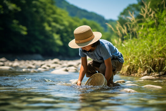 水遊びをしている麦わら帽子の少年