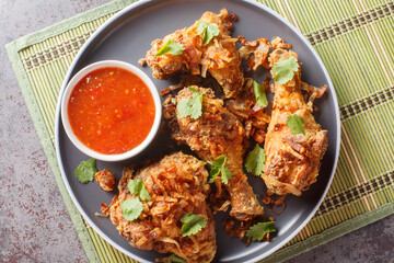 Thailand Hat Yai fried chicken with sweet chili sauce and crispy onions close-up on a plate on the...