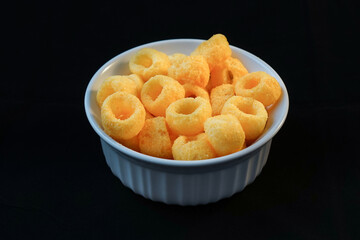 bowl of sweet corn chips on black background