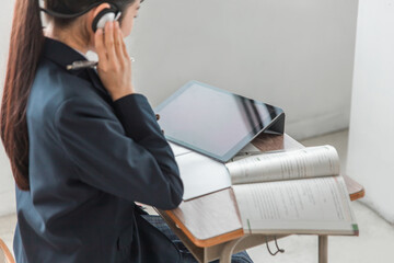 学校の教室・塾でパソコンを使って英語の授業を受ける高校生・女子高生
