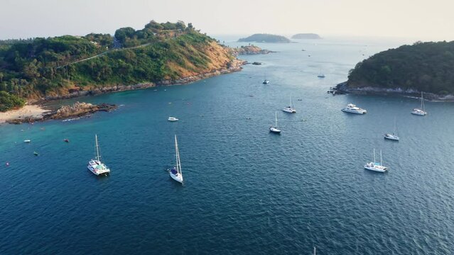 Viewpoints, places to visit in Phuket. Aerial view footage of the beautiful sandy beach and sea. Plenty of water activities. Sailing yacht waiting to watch the sunset.