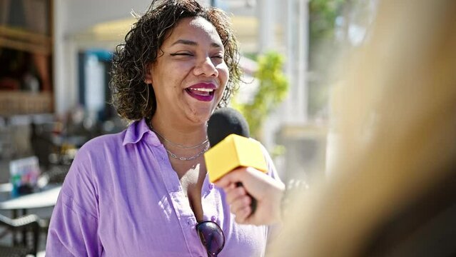 Young beautiful latin woman having interview at street