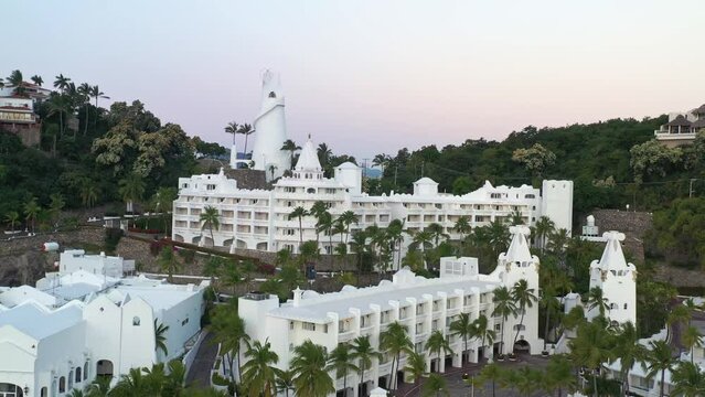 Vuelo de drone sobre hotel de color blanco que va descubriendo el mar en el horizonte. Manzanillo, Colima.
