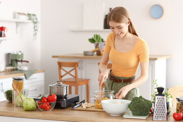 Obraz na płótnie Canvas Young woman preparing pasta in kitchen
