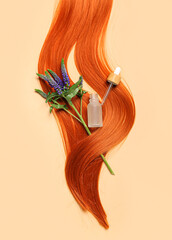 Ginger hair strand, flowers and bottle of essential oil on color background