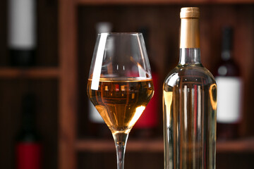 Bottle and glass of exquisite wine in cellar, closeup
