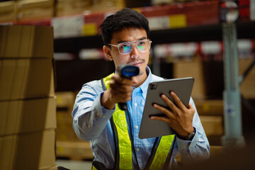 Asian male worker in security suit with tablet computer looking for items in a large warehouse. Logistics and export business Factory warehouse. business Industrial. warehouse.