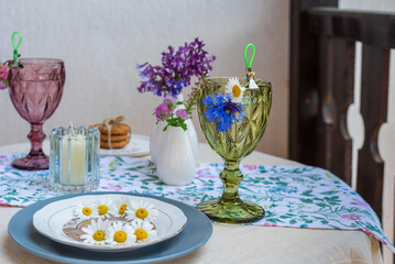 Table on the terrace with soft drinks, flowers and a plate of daisies