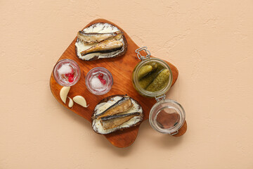 Shots with cold vodka and snacks on beige background