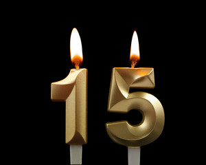 Golden birthday candles isolated on black background. Number 15.