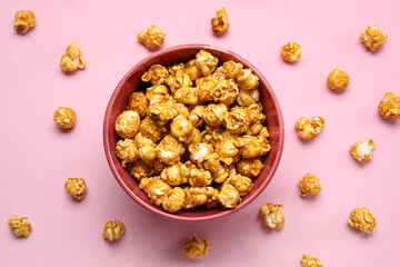 Bowl with tasty popcorn on pink background