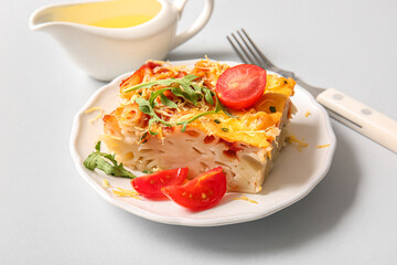 Plate of pasta with tomato sauce and cheese on grey background