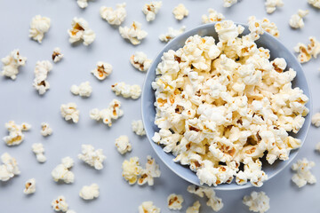Bowl with tasty popcorn on grey background