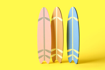 Many different colorful mini surfboards on yellow background