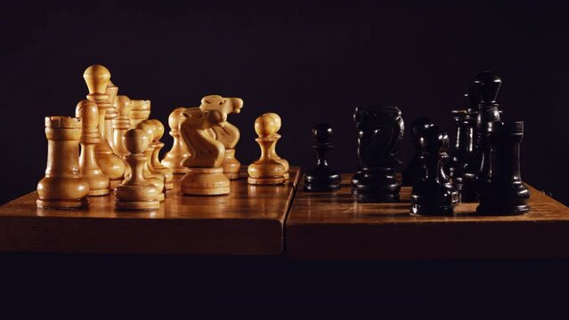 Old chess game with a queen gambit opening on a black background, stop motion