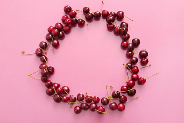 Frame made of sweet cherries on pink background