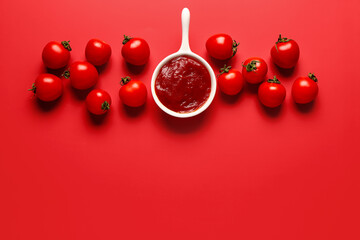 Bowl with tomato paste and fresh vegetables on red background