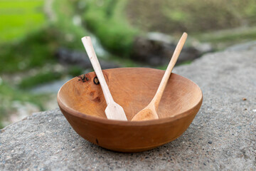 Wooden spoons in a big wooden bowl closeup with blurred background. selective focus.