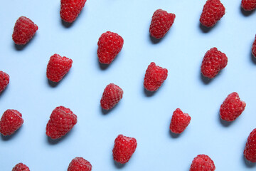 Many fresh raspberries on blue background
