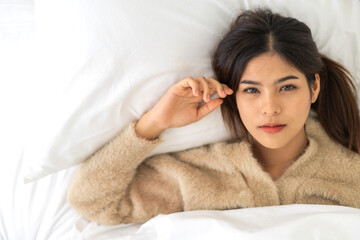 Portrait of smiling cheerful beautiful pretty asian woman clean fresh healthy white skin posing smile in in warm knitted clothes, skincare.Girl felling relax and enjoy time on bed at home.asia beauty
