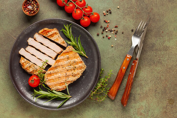 Pork steak on a wooden board a dark background. Top view