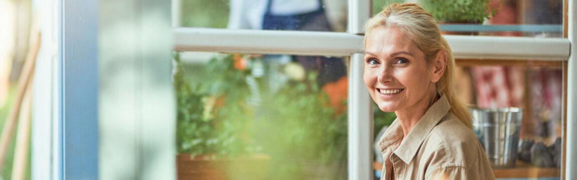 Middle aged caucasian woman sitting next to laptop - Powered by Adobe