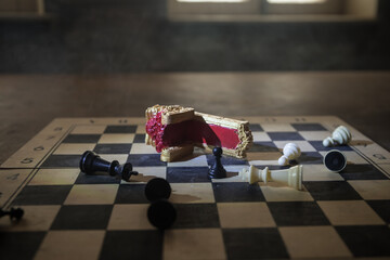 Red royal chair miniature on wooden table. Medieval Throne on chessboard. Chess board game concept...