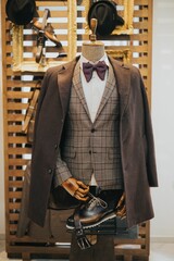 a mannequin holding a suit jacket with some shoes