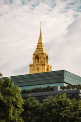 Vertical shot of a beautiful shiny golden historic tower in Bangkok, Thailand