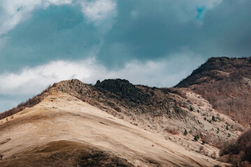 Beautiful landscape of big rocky peaks of the mountains against the blue cloudy stormy sky