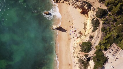 Aerial view of a golden sandy beach with the turquoise sea waters washing the shore