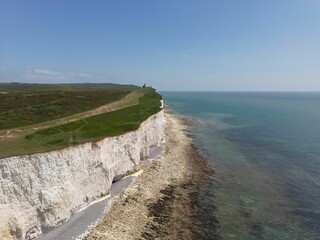 Scenic aerial view of the Seven Sisters Cliff overlooking the expanse of a blue ocean.