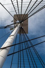 Vertical low angle shot of ship mast against blue cloudy sky