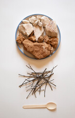 Brown and white clay with sticks and a spoon flat
