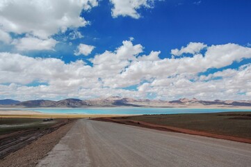 Beautiful view of road leading to a lake and mountains on a cloudy day