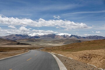 Aerial view of road through desert surrounded by hills