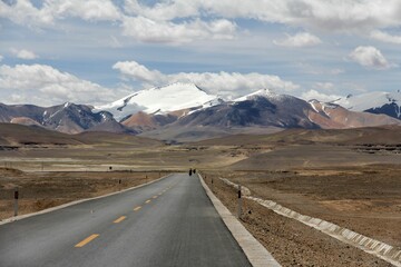 Aerial view of road through desert surrounded by hills