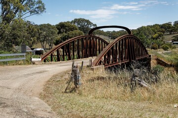 Fototapeta na wymiar Aged metal bridge over a river in the countryside