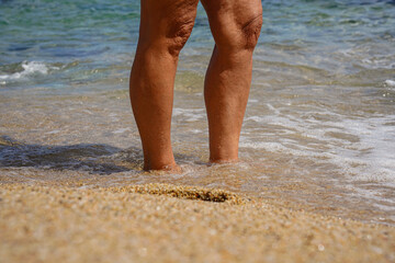 Background of two wet woman legs in the sea in calm vacation.